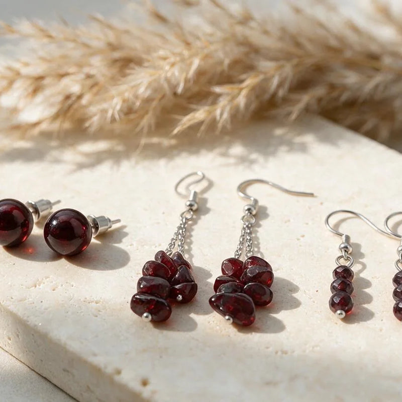 Boucles d'oreilles grenat, pierre naturelle, sur travertin