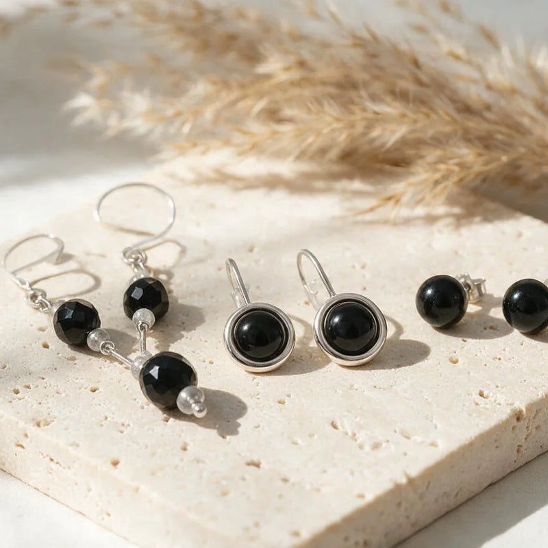 Boucles d'oreilles onyx noir, pierre naturelle, sur travertin