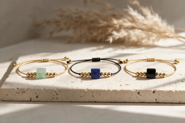 Bracelets cordon doré en pierre naturelle CUBE®, sur travertin