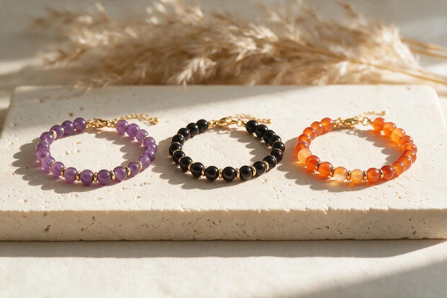 Bracelets fins dorés AURA®, perles 6 mm, sur travertin