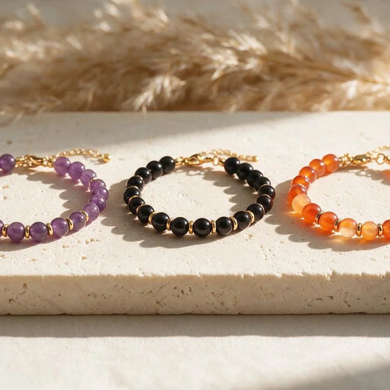 Bracelets fins dorés AURA®, perles 6 mm, sur travertin