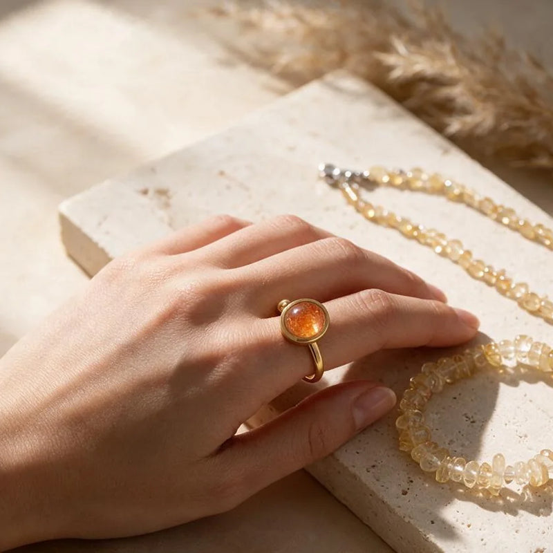 Bijoux et pierres jaune orange, sur travertin