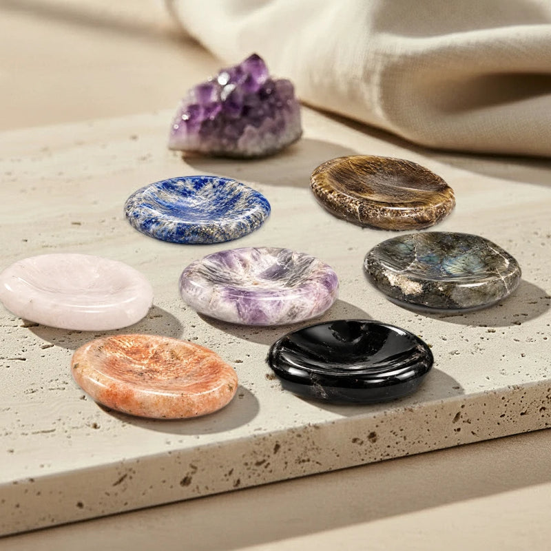 Pierres de pouce anti-stress en pierre naturelle, améthyste, lapis-lazuli, œil de tigre et obsidienne posées sur du travertin