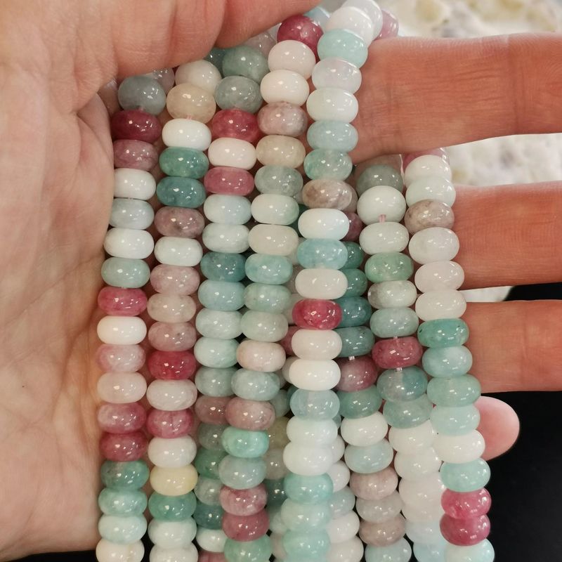 Gros plan sur des perles de Morganite rose tendre forme donut, pierre naturelle semi-précieuse