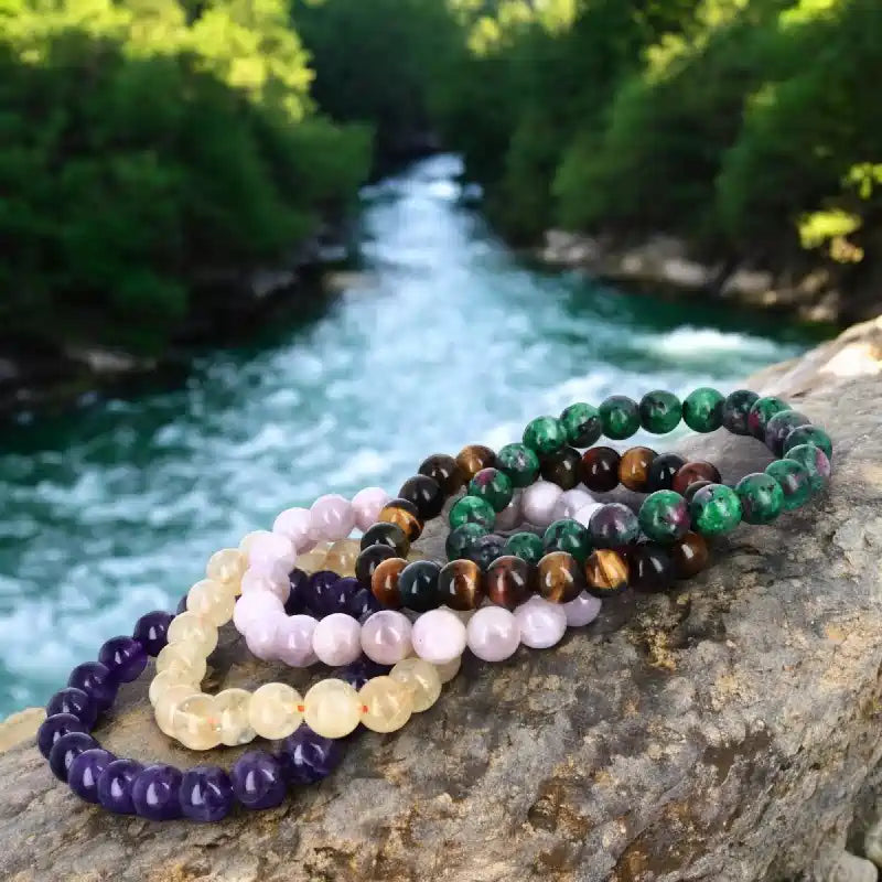 Bracelets en pierres naturelles rondes, aux couleurs variées et finitions polies, présentés en collection. Bijoux en pierres authentiques pour bien-être et élégance.