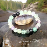 Détail perles multicolores translucides du bracelet pierre naturelle Fluorite véritable. Qualité lithothérapie pour protection énergétique et équilibre.