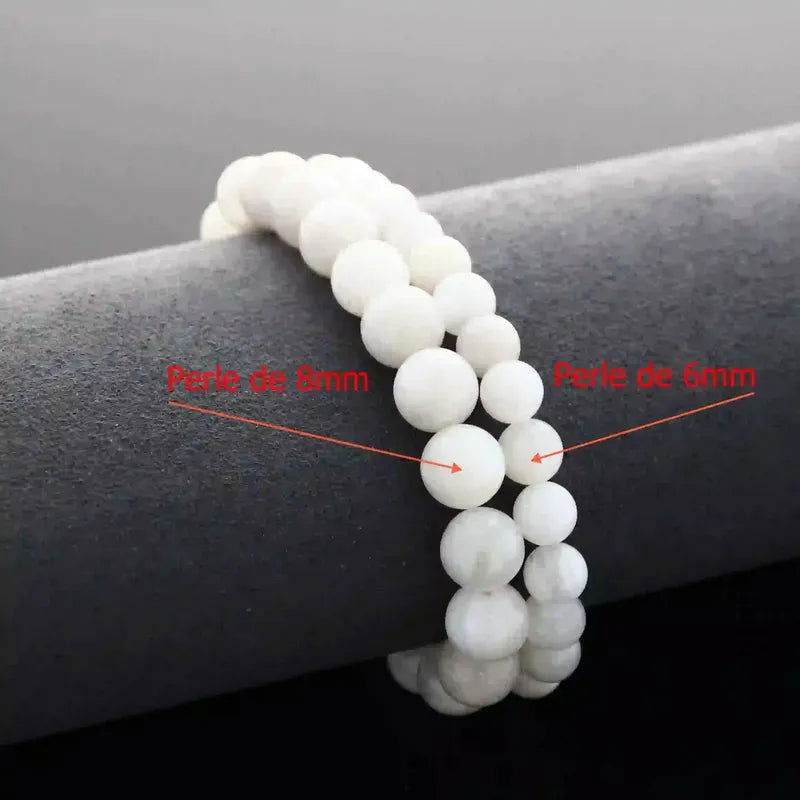 Bracelet de lithothérapie en Pierre de Lune véritable porté, bijou pierre naturelle douce pour équilibre émotionnel et chakra troisième œil.