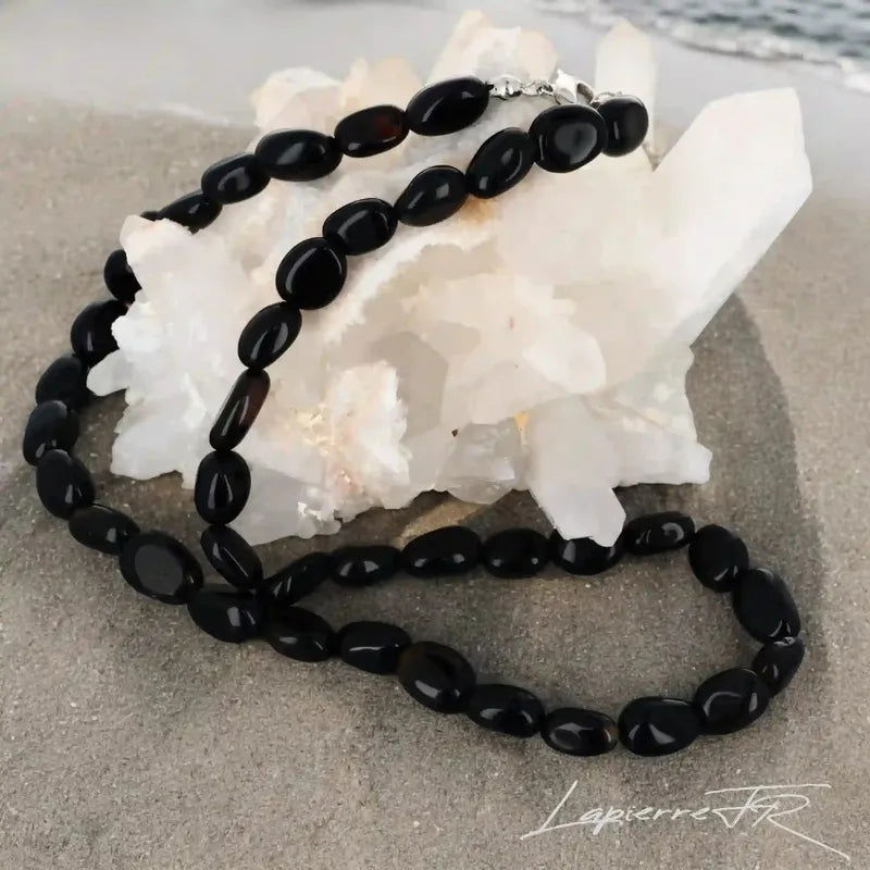 Détail des pierres roulées d'Onyx Noir du collier, pierre naturelle noire d'ancrage