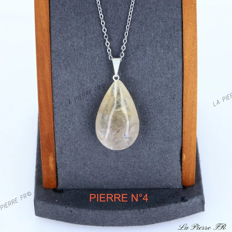 Gros plan sur le pendentif Quartz Rutile du Brésil, cheveux de Vénus dorés, bijou naturel