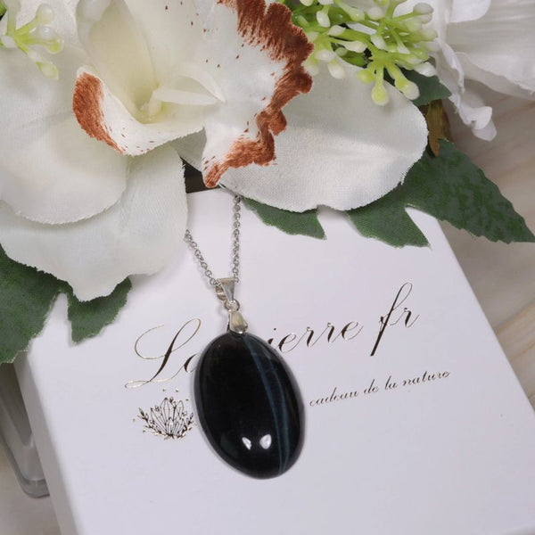 Gros plan sur le pendentif ovale Œil de Faucon, pierre naturelle de clarté pour collier
