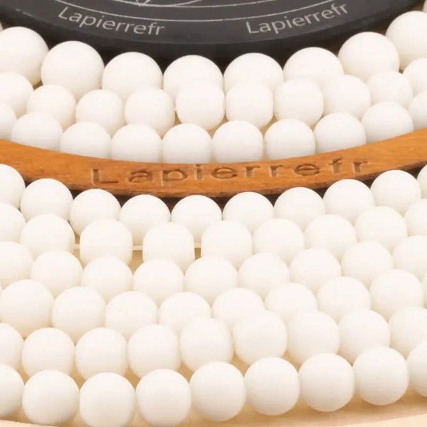 Gros plan sur des perles d'Onyx blanc, pierre naturelle ronde et lisse pour bracelet et collier
