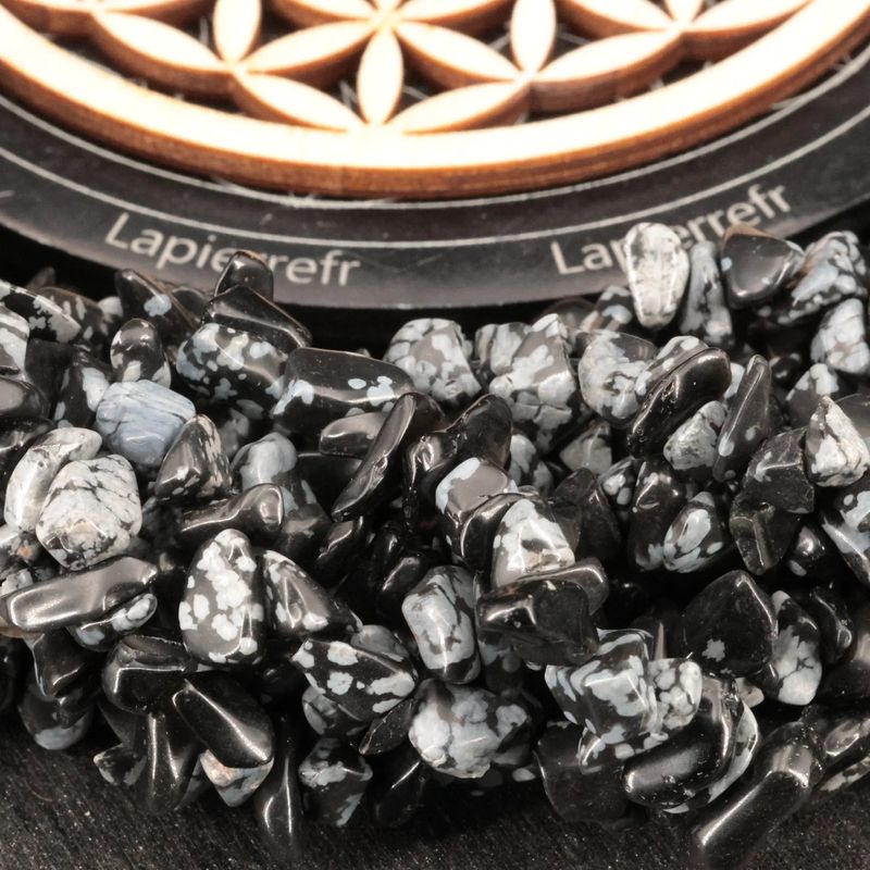 Gros plan sur des perles baroques d'Obsidienne Neige, pierre naturelle noire mouchetée sur fil de 36 cm pour bijoux