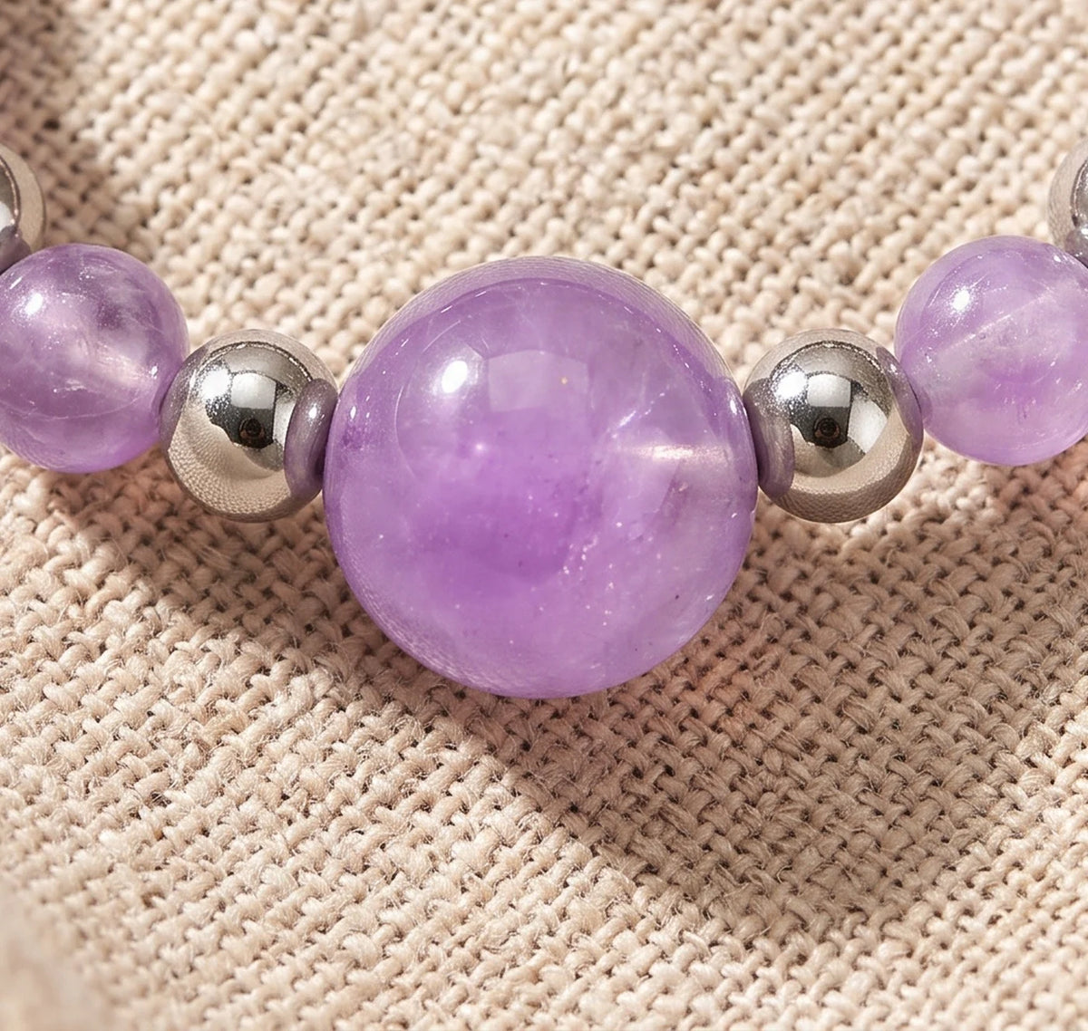 Gros plan sur les perles d'améthyste de la bague élastique ALÉNA®