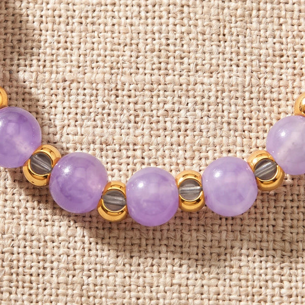 Gros plan sur les perles d'améthyste de la bague élastique MIRÉA®