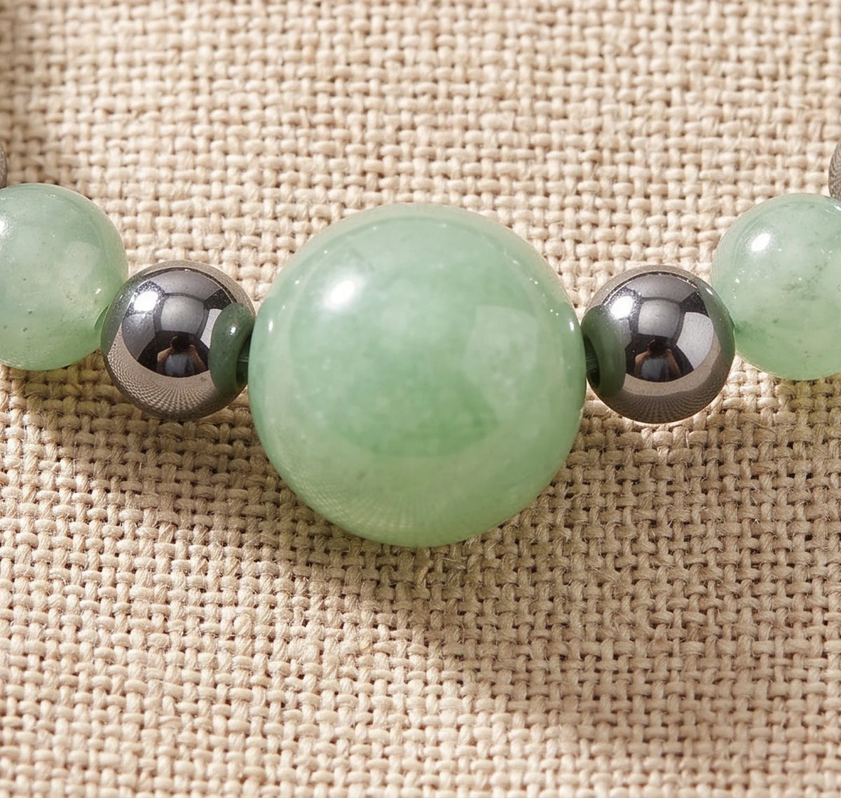 Gros plan sur les perles d'aventurine verte de la bague élastique ALÉNA®