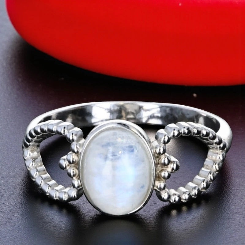 Bague en Pierre de Lune (Cœur Astral) — gros plan du cabochon et des motifs cœurs