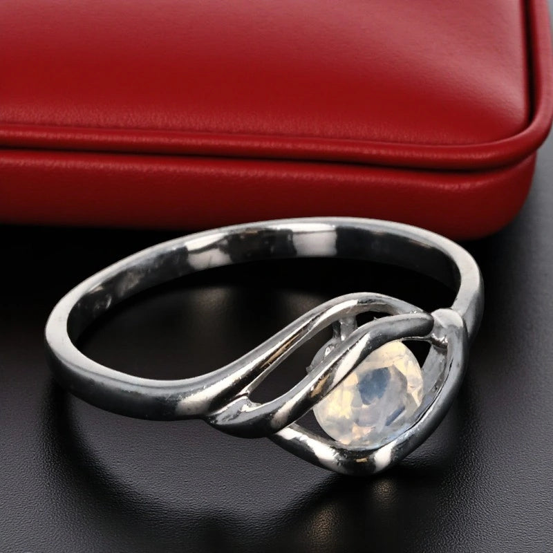 Bague en Pierre de Lune (Rayon Nacré) — gros plan, pierre ronde 5 mm en argent rhodié, monture design torsadée