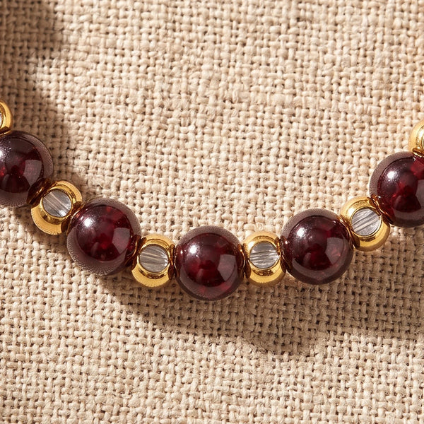 Gros plan sur les perles de grenat rouge de la bague élastique MIRÉA®