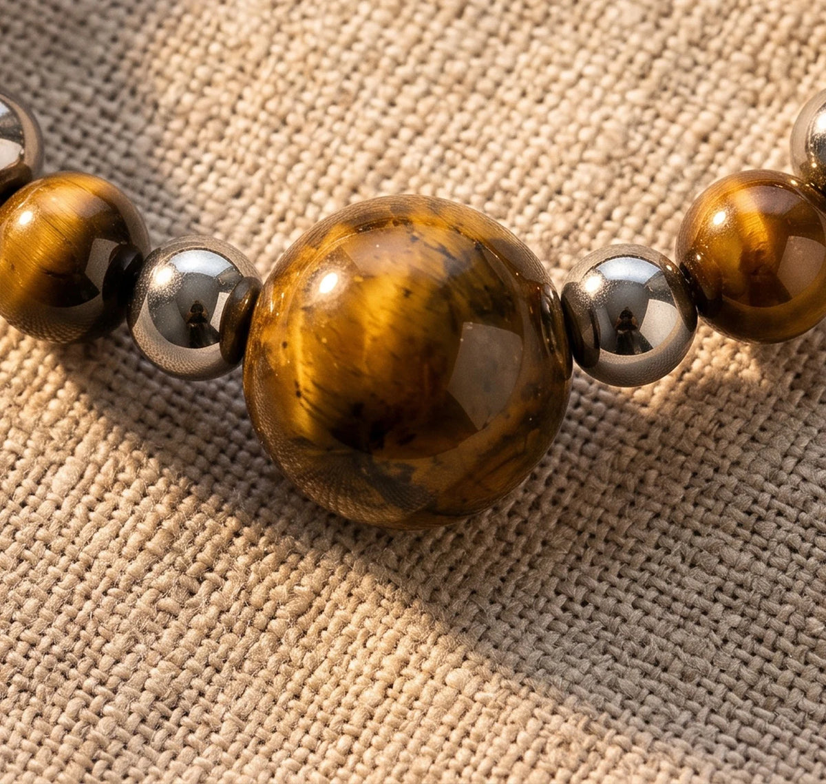 Gros plan sur les perles d'œil de tigre de la bague élastique ALÉNA®