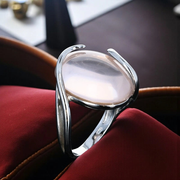Bague en Quartz rose (Volute Spirale) — portée au doigt, cabochon ovale très grand