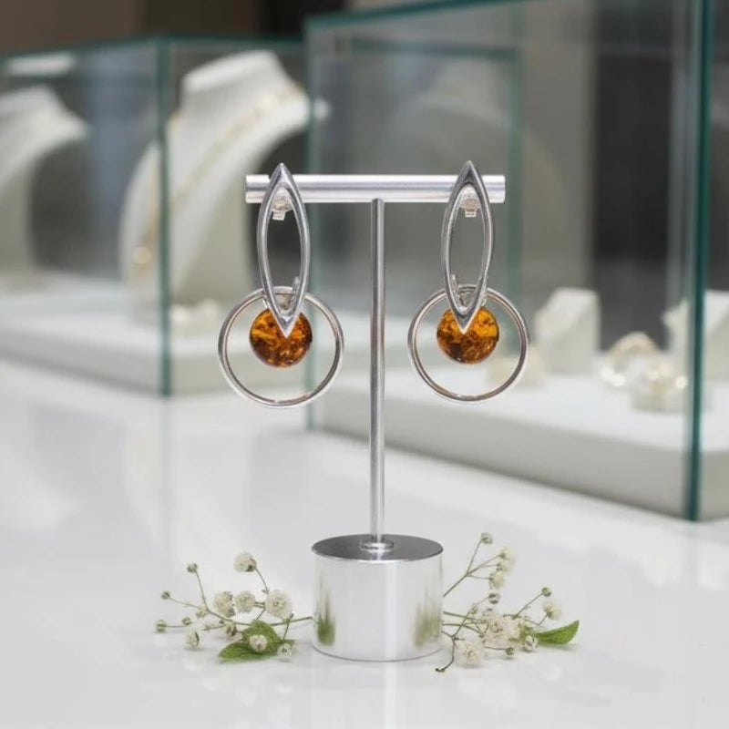 Gros plan sur la pierre et la monture des boucles d'oreilles Gienah en ambre