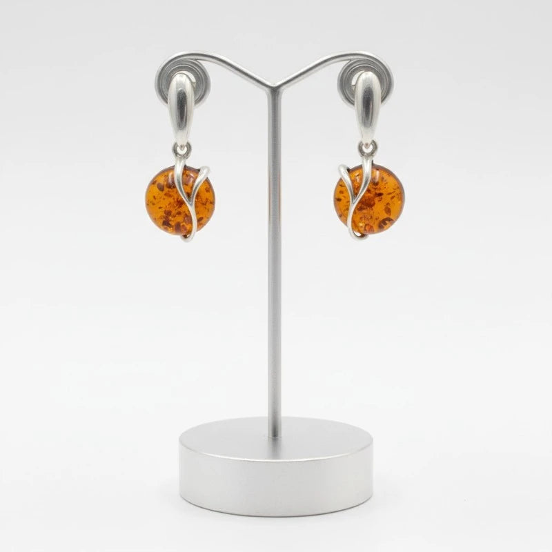 Gros plan sur la pierre et la monture des boucles d'oreilles Capella en ambre