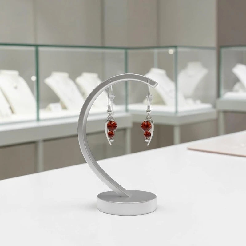 Gros plan sur la pierre et la monture des boucles d'oreilles Alkaïd en ambre