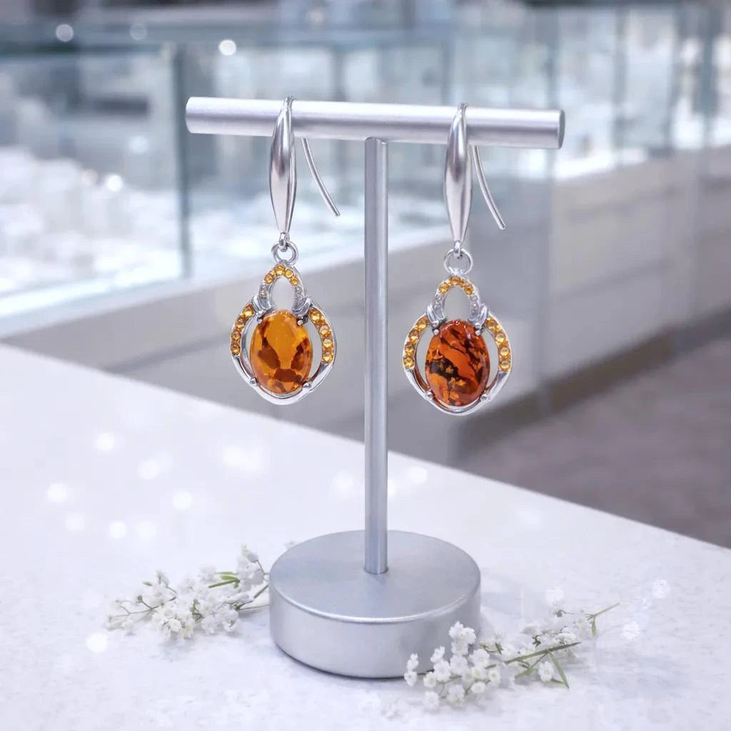 Gros plan sur la pierre et la monture des boucles d'oreilles Hamal en ambre