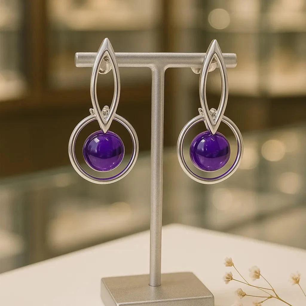 Gros plan sur la pierre et la monture des boucles d'oreilles Naos en améthyste