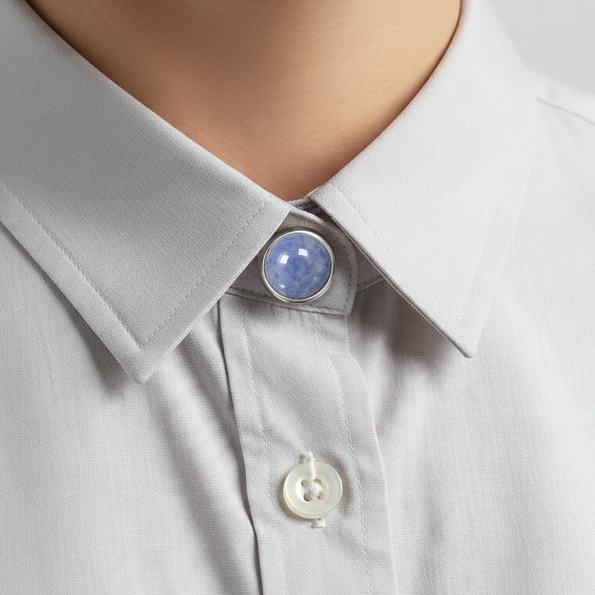 Bijou de col de chemise en aventurine bleue, clipsé au col d'une chemise gris clair