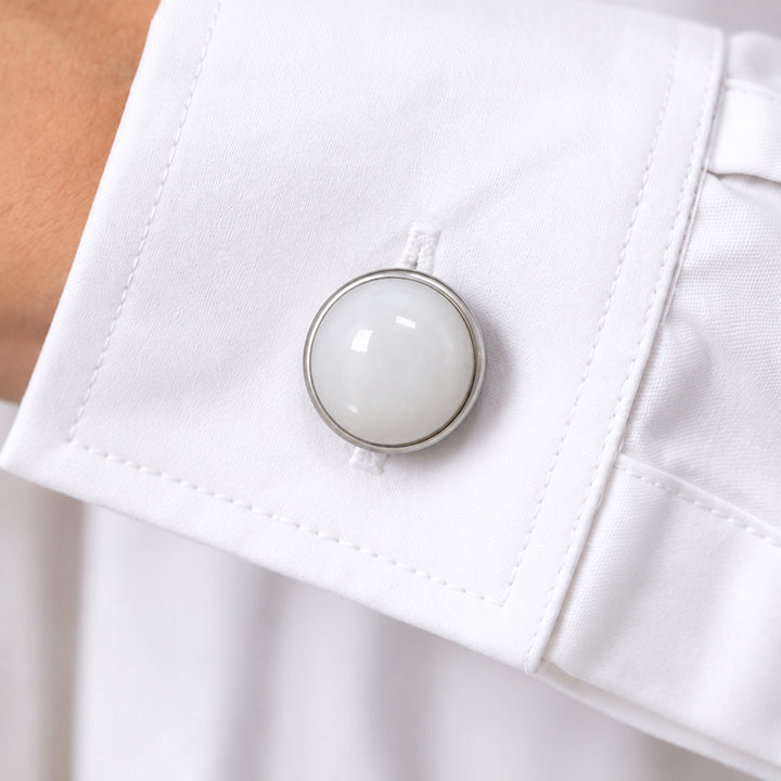 Cache bouton en jade blanc clipsé sur le bouton du poignet d'une chemise blanche