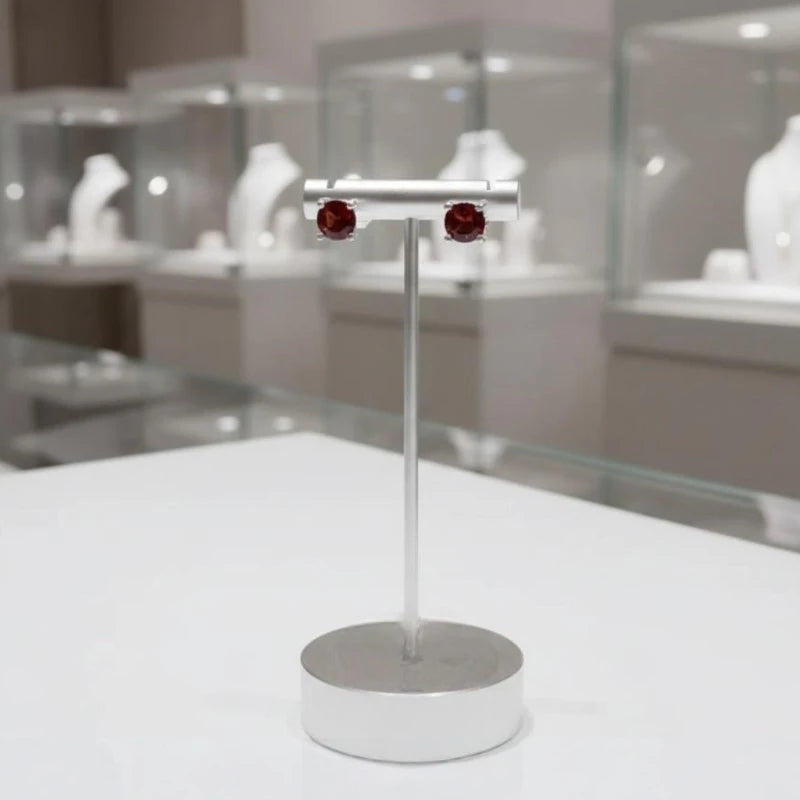 Gros plan sur la pierre et la monture des boucles d'oreilles Tarazed en grenat