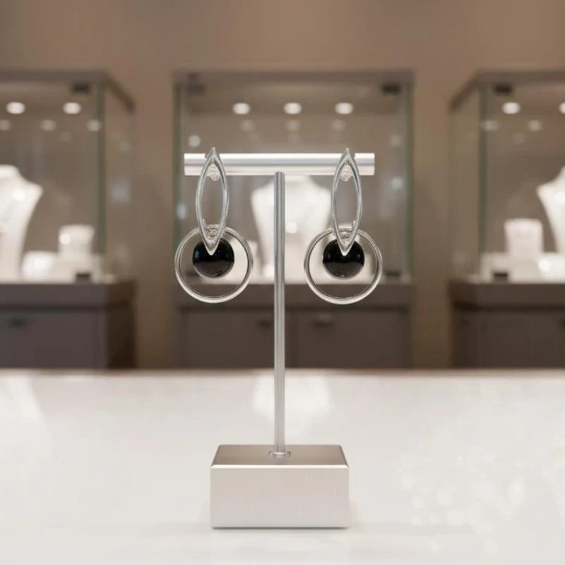 Gros plan sur la pierre et la monture des boucles d'oreilles Denebola en onyx noir