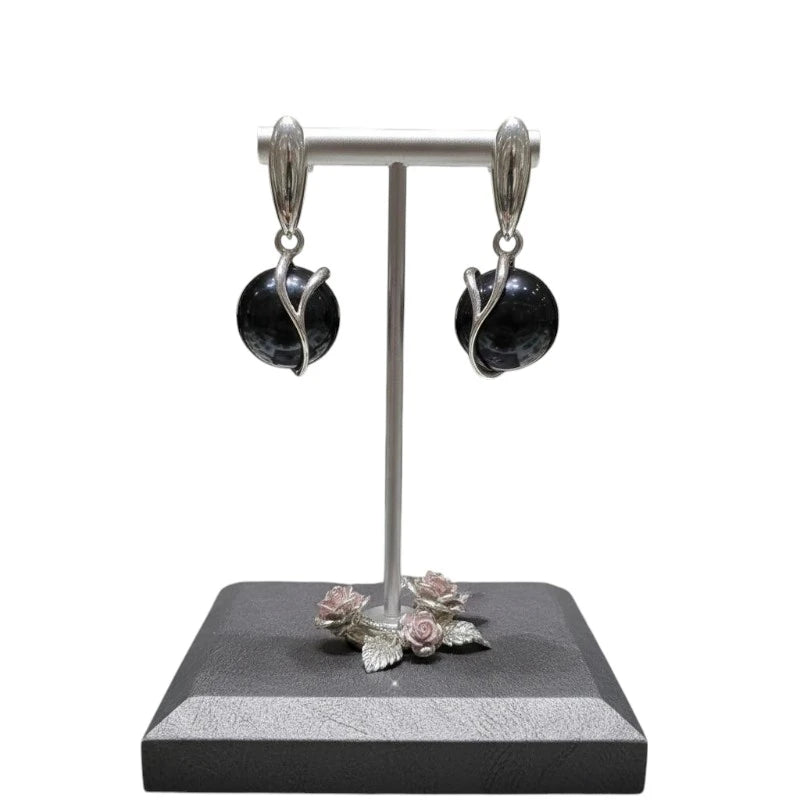 Gros plan sur la pierre et la monture des boucles d'oreilles Antarès en onyx noir