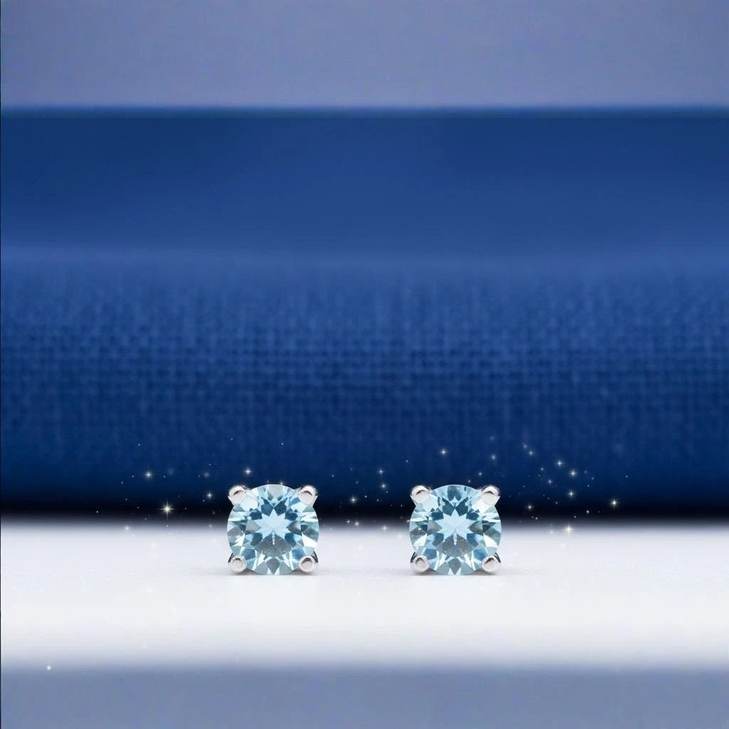 Gros plan sur la pierre et la monture des boucles d'oreilles Asterion en topaze bleue