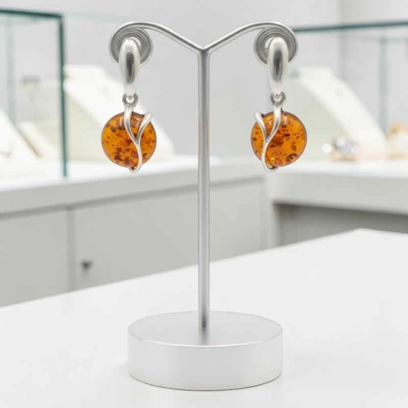 Boucles d'oreilles Capella en ambre et argent 925 rhodié, présentées sur un support