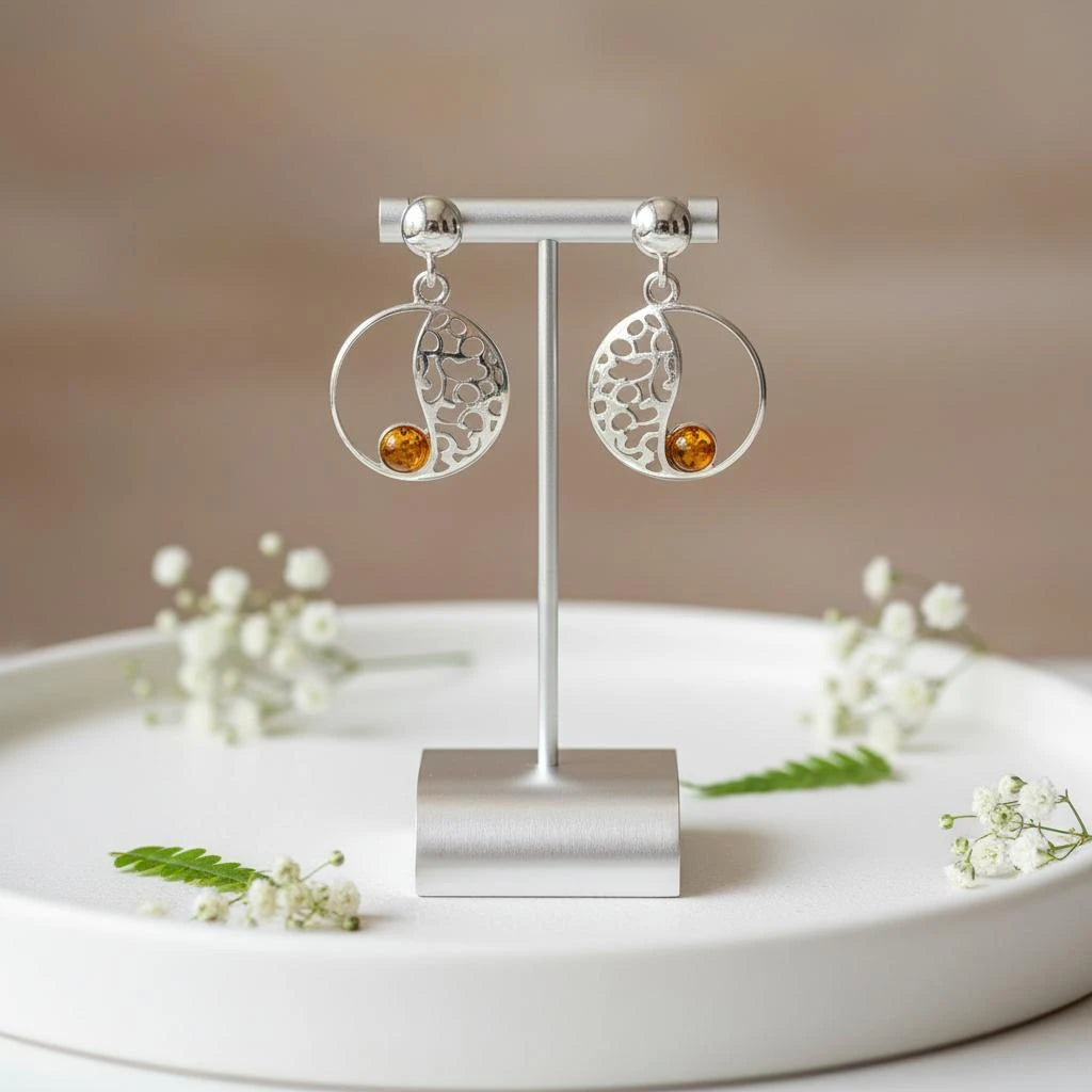 Boucles d'oreilles Elnath en ambre et argent 925 rhodié, présentées sur un support