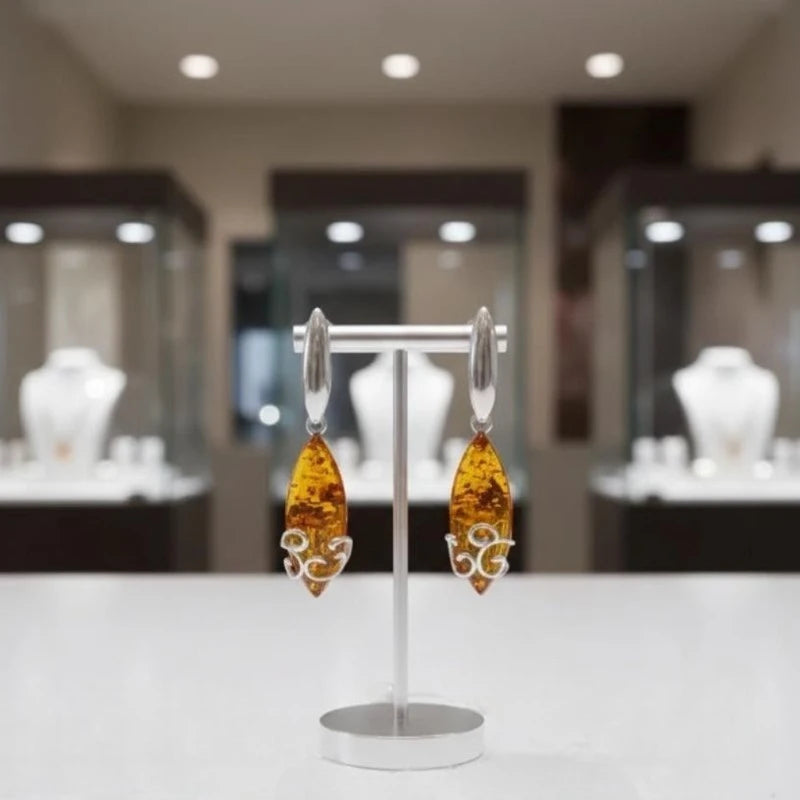 Boucles d'oreilles Merak en ambre et argent 925 rhodié, présentées sur un support