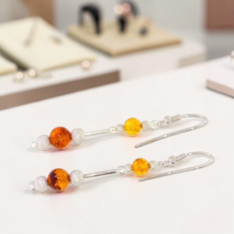 Gros plan perles ambre rondes 6mm et 8mm boucles Izar