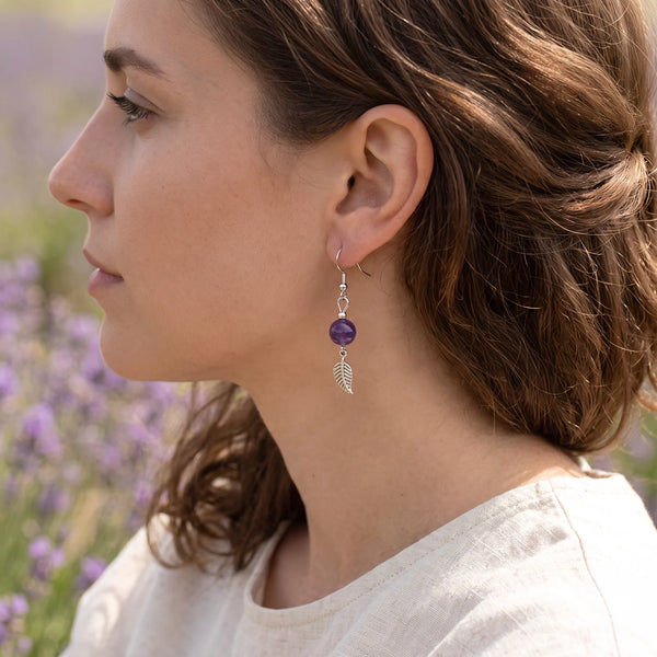 Boucle d'oreille améthyste et feuille en acier inoxydable, portée à l'oreille