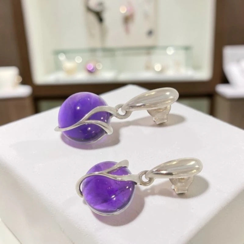 Paire de boucles d'oreilles améthyste Aldébaran sur fond blanc, argent 925 rhodié