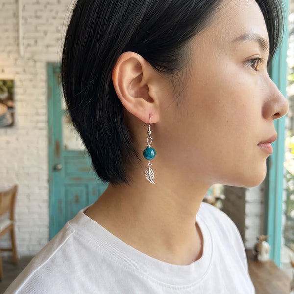 Boucle d'oreille apatite bleue et feuille en acier inoxydable, portée à l'oreille