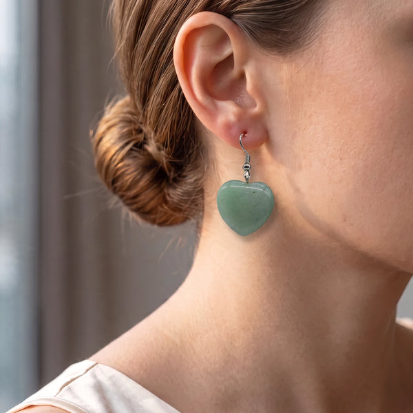 Boucles d'oreilles cœur en aventurine verte portées par une femme, pendantes 4 cm sur crochet argenté