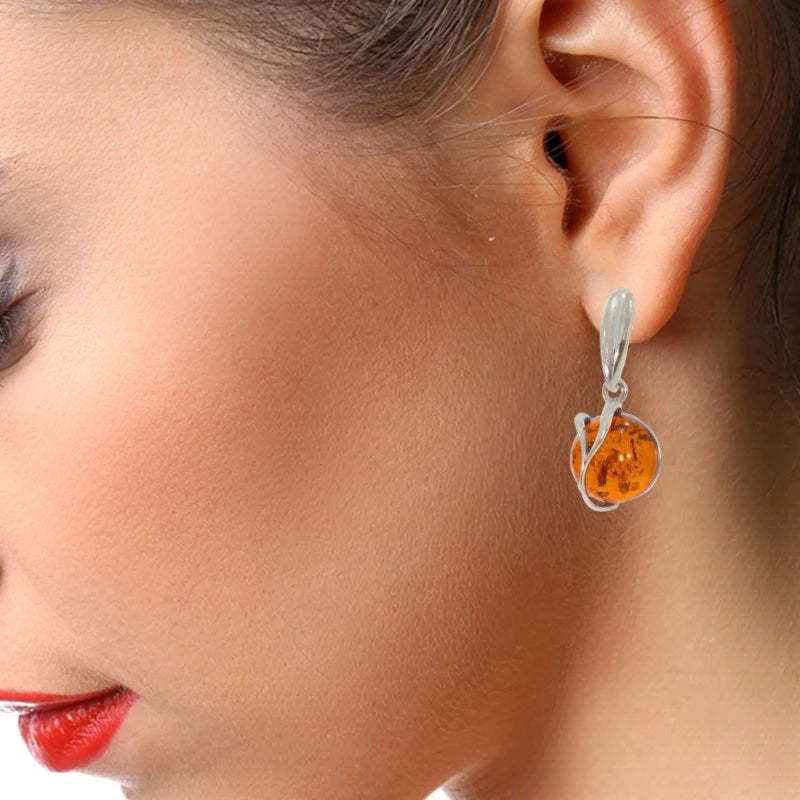 Boucles d'oreilles ambre Capella portées à l'oreille, gros plan