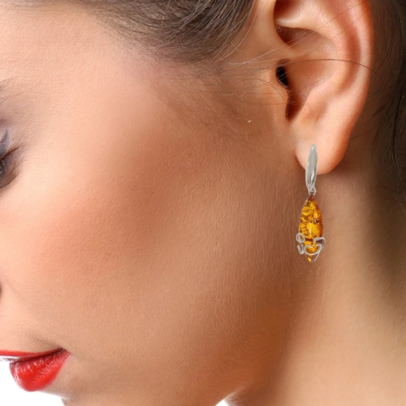 Boucles d'oreilles ambre Merak portées à l'oreille, gros plan