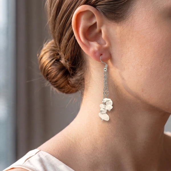 Boucle d'oreille bohème en chips de howlite blanche portée par une femme, chaîne argentée