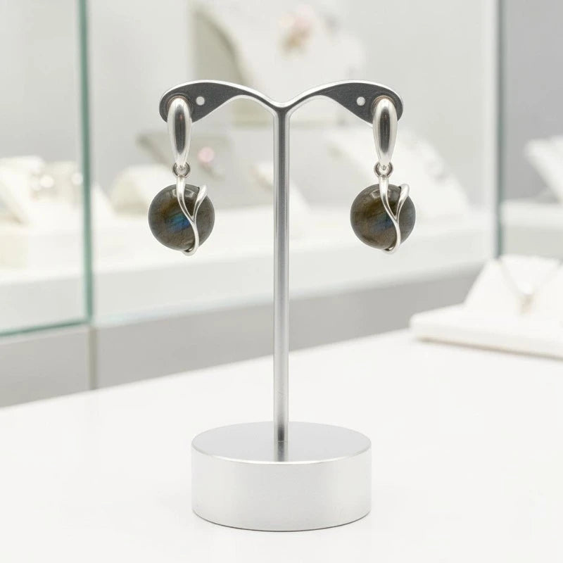 Boucles d'oreilles Arcturus en labradorite et argent 925 rhodié, présentées sur un support
