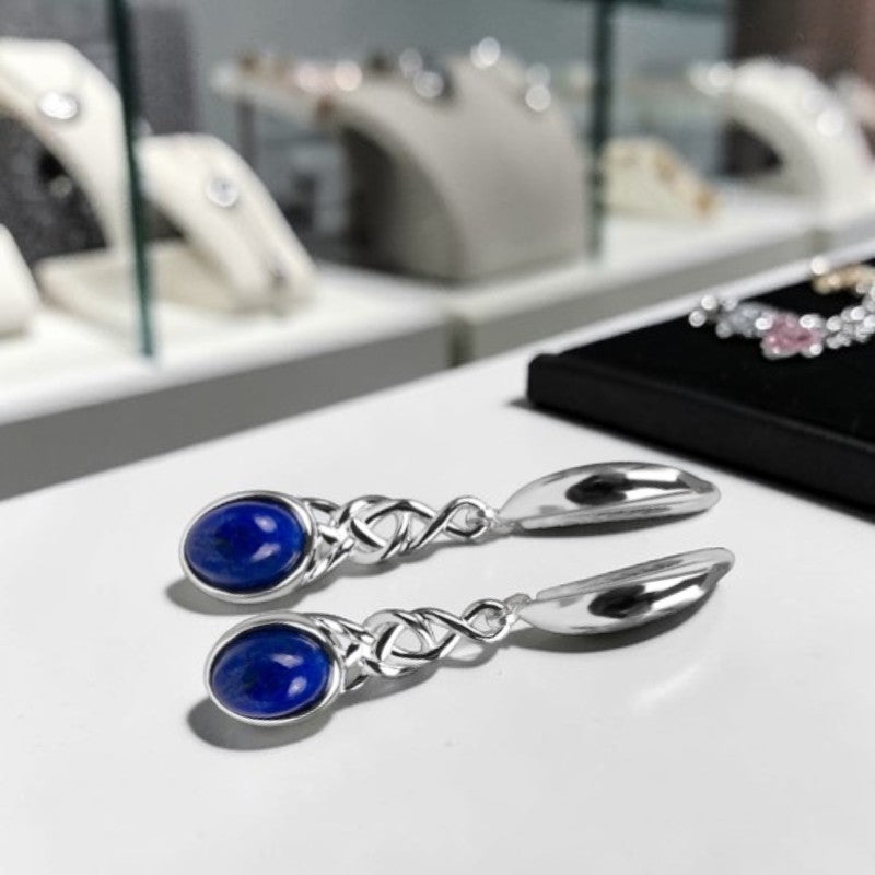 Gros plan cabochon lapis-lazuli bleu intense ovale boucles Sadalsuud