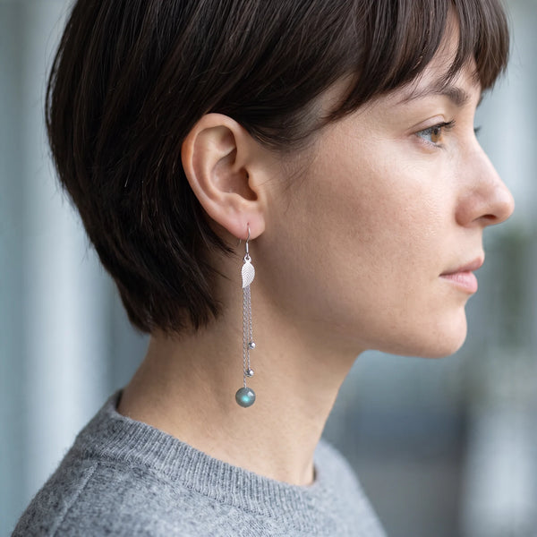 Boucle d'oreille longue en argent massif et labradorite, portée à l'oreille