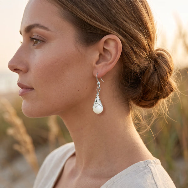 Boucle d'oreille nacre à calotte filigrane en acier inoxydable, portée à l'oreille